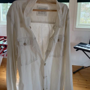 Vit skjorta från Selected Homme - Säljer en stilren vit skjorta från Selected Homme med klassisk krage och två bröstfickor med knappar. Skjortan har långa ärmar och är perfekt för en clean och enkel look.