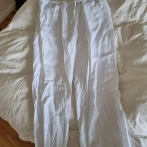 Vita linnebyxor med resårmidja L - Säljer ett par fräscha vita linnebyxor med avslappnad passform och resår i midjan. Perfekta för varma dagar och riktigt sköna att bära. Luftiga och stilrena, passar till allt från sneakers till sandaler.