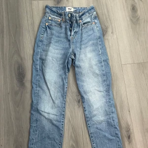 Blå raka jeans från 157, XXS - Snygga ljusblå jeans från 157 i rak modell med klassisk femficksdesign och knappgylf. Jeansen är tillverkade i jeansmaterial och har en hög midja. Perfekta för dig som gillar en clean och tidlös look.