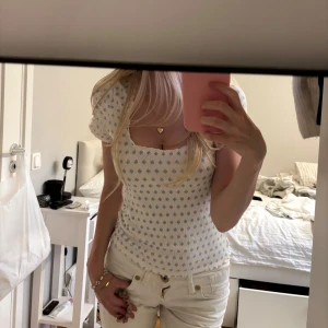 Vit topp med blått mönster - Supersöt topp från Lindex i vitt med små blå mönster. Den har fyrkantig ringning och vågig kant vid halsen. Bra material💕💕 passar xs-s. 