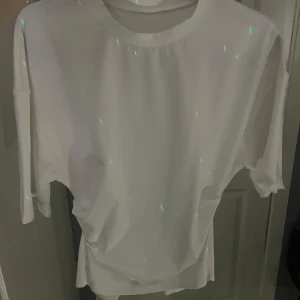 Vit basic t-shirt med loose fit - Enkel vit t-shirt med rund hals och korta ärmar. Modellen är loose fit och passar perfekt till ett avslappnat streetwear-utseende. T-shirten är tillverkad i mjuk bomull och har en clean, minimalistisk look utan tryck eller mönster.