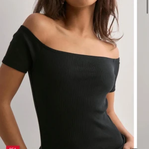 Svart offshoulder topp från Nelly - Svart ribbad offshoulder topp från Nelly i storlek XS. Inte använd något. Helt nytt skick