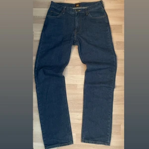 Mörkblå Lee jeans straight fit - Säljer ett par mörkblåa straight jeans från Lee. Skicket är väldigt bra. Nästan aldrig använda Pris kan diskuteras vid snabb affär!                       Storlek W 31 L 32