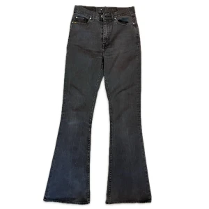Svarta bootcut jeans Tiger of Sweden - Snygga svarta bootcut jeans från Tiger of Sweden, modell Caprice. Jeansen har hög midja och är tillverkade i ett mörkt tvättat bomullsjeansmaterial. 