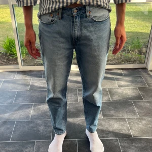 Levi's 562 ljusblå jeans W32 L34 - Säljer ett par klassiska Levi's 562 jeans i ljusblå denim. De har rak passform, fem fickor och den ikoniska röda Levi's-taggen bak. Jeansen är tillverkade i bomull och har en avslappnad, loose fit med hög midja. Perfekta för en chill och tidlös look.