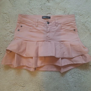 Rosa volangkjol  - Supersöt ljusrosa kortkjol som jag sytt själv med volangdetalj och klassisk jeanslook. Kjolen har fickor fram och bak, perfekt för dig som vill ha en feminin och trendig stil.