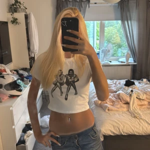 Vit croppad t-shirt med tryck - Säljer en vit croppad t-shirt med ett svartvitt tryck framtill. 💘
