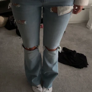 Low bootcut jeans med hål - Säljer dess low bootcut jeansen dom är låga i midjan men inte jätte låga och dom är i storlek s och passar mig perfekt som är 164, midjemått: 36, innerbenslängd: 76