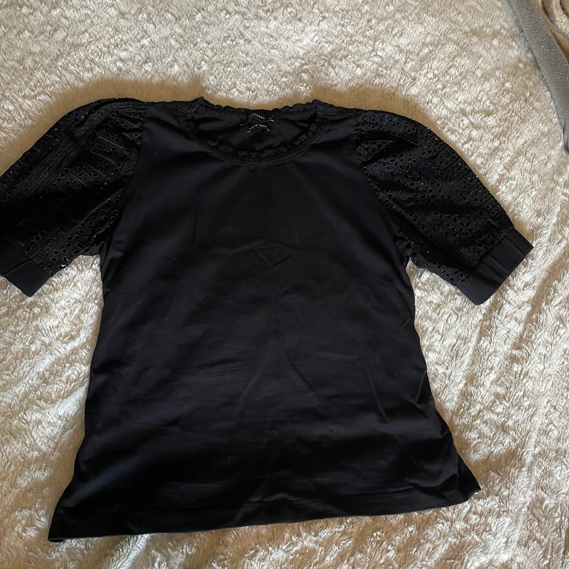 Svart blus med broderade puffärmar