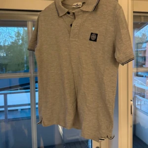 Grå pikétröja från Stone Island - Säljer denna superfina pikén från Stone Island i storlek M! Den är sparsamt använd och har inga synliga tecken på användning🤍