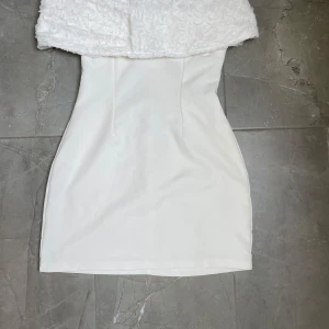 Vit klänning  - Super fin bandou klänning. 3d blommönster på klänningens övre del. Använd 1 gång under student. Nypris 800kr 