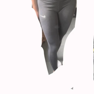 Grå träningstights från Nike - Snygga grå träningstigts från Nike i storlek S. Mycket bra skick och använda ett fåtal gånger. Jag skulle säga att den är liten i storleken så tightsen är mer än XS än S.