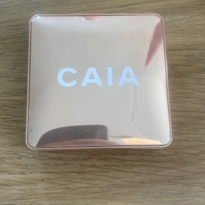 Highlighter från CAIA - Elegant highlighter från CAIA i nyansen Saint Tropez. Kommer i en stilren, roséguldfärgad förpackning med inbyggd spegel. Perfekt för att ge ansiktet en strålande lyster. Endast testad 