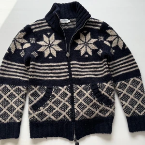 stickad cardigan från Moncler  - Äkta stickad cardigan från Moncler kvitto från sicuro och äktihetsbevis finns! Säljer en snygg stickad kofta från Moncler i mörkblått och beige med ett klassiskt mönster storlek M. Köpt på sicuro kvitto och äktehrtsbevus finns! Koftan har dragkedja och ribbad krage, perfekt för kyliga dagar. Den har långa ärmar och praktiska fickor framtill.