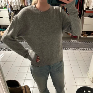 Grå stickad tröja uniqlo - Säljer en mysig grå stickad tröja med rund hals och långa ärmar. Perfekt för kyligare dagar. Tröjan har ribbade muddar vid ärmslut och nederkant för extra komfort.