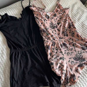 Svart och rosa blommig byxdress från Gina Tricot - Två byxdress från Gina Tricot i storlek S. En svart  med volangdetaljer och en rosa  med blommigt mönster. Två i ett 