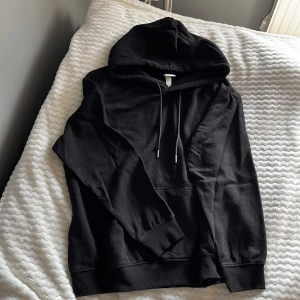 Svart hoodie från H&M - Säljer en klassisk svart hoodie från H&M. 