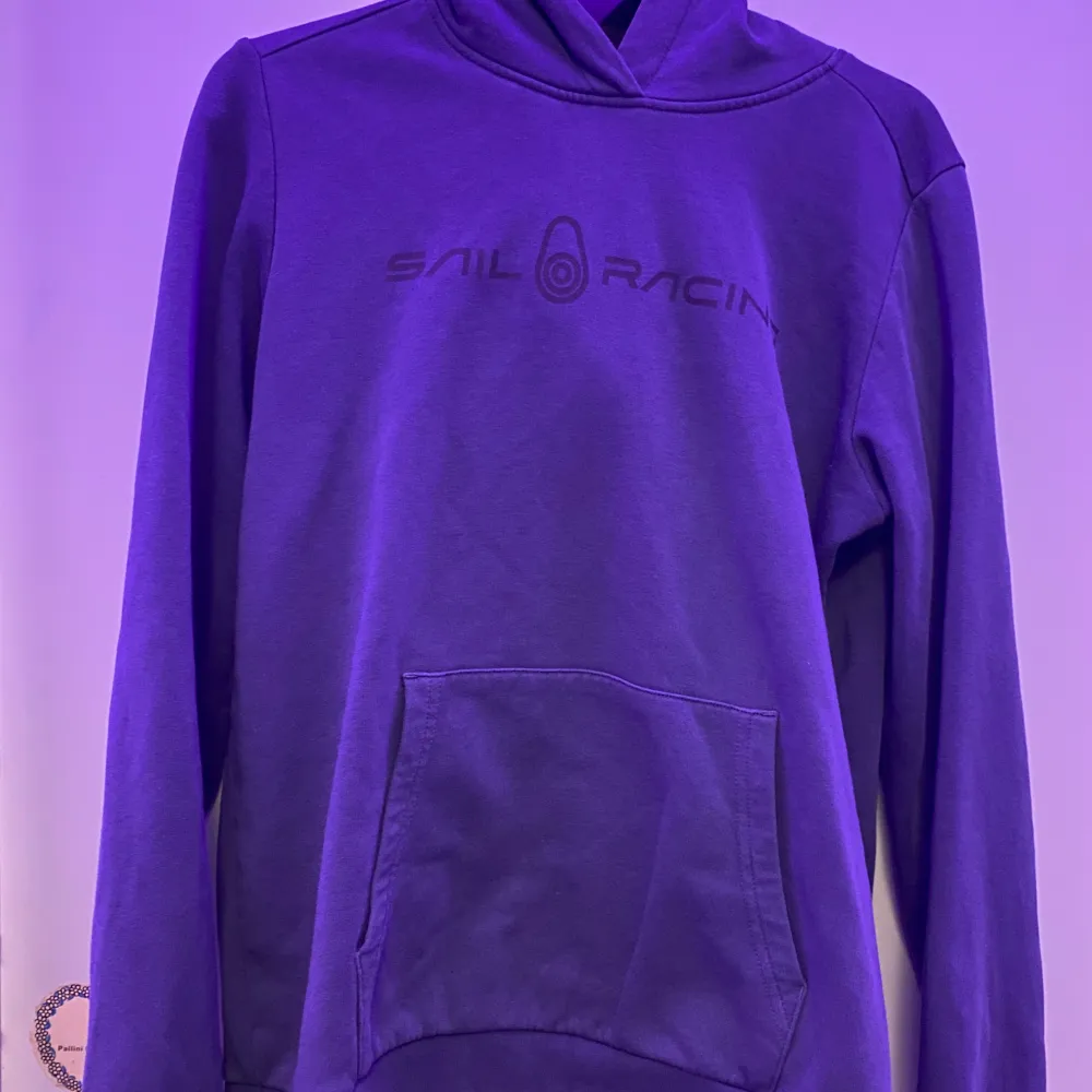 Säljer en snygg blå hoodie från Sail Racing. Den har en klassisk design med en stor ficka framtill och en bekväm huva. Perfekt för kyliga dagar och avslappnade stunder. Passar både för vardag och fritid.. Neuletakit & Villapaidat.