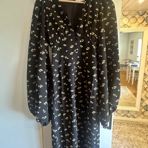 Svart blommig klänning från Adoore - Oanvänd långklänning, med lappen kvar, från Adoore med ett sött blommönster. Perfekt för både vardag och speciella tillfällen. 🌸Endast testad och tyvärr för liten. Strl 32 men skulle säga att den även passar 34/S!