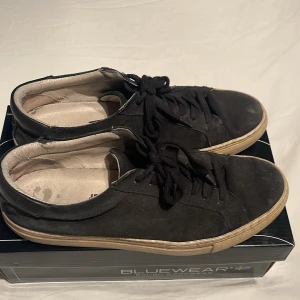 Svarta sneakers från Jack & Jones - Säljer ett par svarta sneakers från Jack & Jones. Skorna har en klassisk design med snörning och rund tå. De är tillverkade i mocka och har en slitstark sula. Perfekta för en avslappnad stil. Skick: 5/10