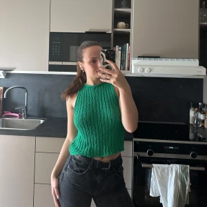 Grön ribbad linnetopp - Snygg grön ribbad linnetopp med en croppad passform. Perfekt för varma dagar och att matcha med jeans eller kjol. Enkel och stilren design som ger en fräsch look.
