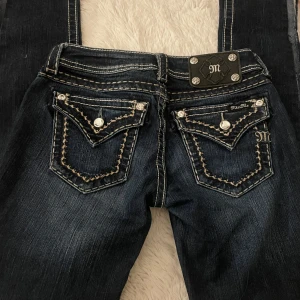 Mörkblå jeans från Miss Me - Snygg mörkblå lågmidjade jeans från miss me. Uppklippta längst ner då jag skulle sy dom till bootcut men blev aldrig av. Priset kan diskuteras vid snabbt köp.                                        Innerbens längd: cirka 75 cm midjemått: 35 cm 