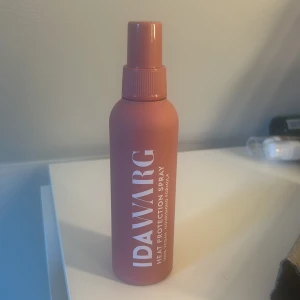 Heat Protection Spray från Ida Warg - Säljer en värmeskyddande spray från Ida Warg. Flaskan är i en snygg terrakottafärg och innehåller en formula som skyddar håret mot värmeskador vid styling. Perfekt för att hålla håret friskt och glansigt. aldrig använd 