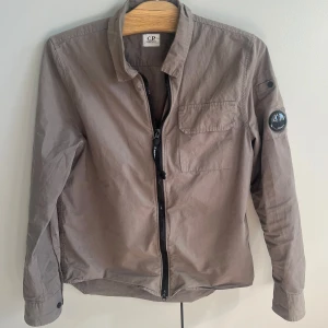 C.P. Company overshirt - Säljer en stilren grå jacka från C.P. Company. Jackan är strl M men sitter som S, säljer eftersom den utber passar mig längre. Jackan är en blandning mellan grå och olivgrön skulle jag säga