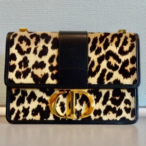 Christian Dior 30 Montaigne in Pony Hair Leather with Leopard Print. - The strap is removable and adjustable  The bag can be used as a crossbody bag, shoulder bag or a clutch.   The condition:   -very good condition on the pony leather skin, no mark or scratch.   -good condition on the interior. There are some tiny scratches inside the bag.    - small scratches on the inner flap.  -the bag strap is a bit wrinkled.  -the discoloration on the goldtone CD clasp at the front, see the picture.  The bag will be delivered together eith the dustbag and authencity card. 
