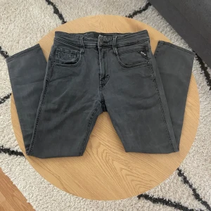Mörkgråa Replay - Tja👋 Säljer ju dessa feta mörkgråa jeans från Replay med klassisk femficksdesign och diskreta sömmar på bakfickorna🪡 Jeansen har normal passform och är tillverkade i mjukt bomullsmaterial med lite stretch för extra komfort👖 Perfekta för en clean look🤩  Storleken är W30(35cm) L32(87cm)📏  Vid fler frågor: Meddela oss📩
