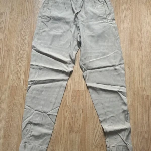 Beige pull-on byxa med snörning och resår - Snygga beige byxor med resår i midjan och snörning framtill. Modellen är rak med avsmalnande ben och har fickor på sidorna. Perfekta för en chill och avslappnad stil