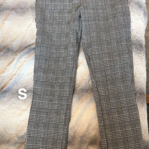 Grå rutiga kostymbyxor  - Snygga grå kostymbyxor med klassiskt rutigt mönster. Byxorna har rak passform och är perfekta för en stilren look. Tillverkade i ett mjukt och bekvämt material som känns skönt hela dagen.🌸Fint använt skick. Storlek s