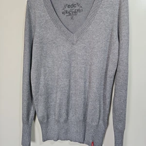 Grå v-ringad tröja från Esprit - Snygg grå v-ringad tröja från Esprit (edc) i storlek XL. Jag skulle säga att den är en storlek M.  Tröjan har ribbade muddar och är tillverkad i en mjuk blandning av viskos, bomull, polyamid och polyester. Aldrig använd.  