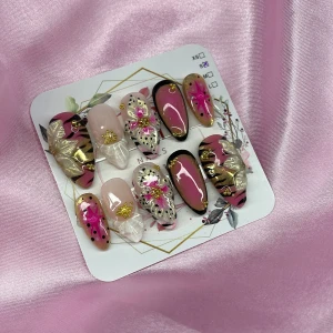 TropicDoll (S);Medium Almond - Snygga gelé press-on naglar i en medium mandelform med mix av rosa, svart, guld och nude. Designen har detaljer som blommor, stjärnor, prickar och 3D-rosetter. Perfekt för dig som vill ha unika och kreativa naglar utan att gå till salong. I storlek S: 15 mm, 11,5 mm, 12 mm, 11 mm, 9 mm 