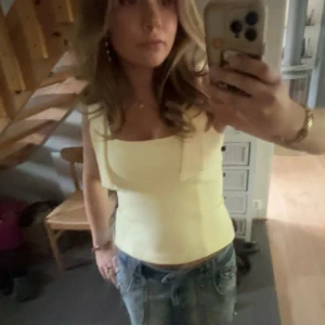 Trendig topp - Snygg ljusgul linnetopp med breda axelband och dekorativa knytband upptill. Har endast använt en gång!!💛