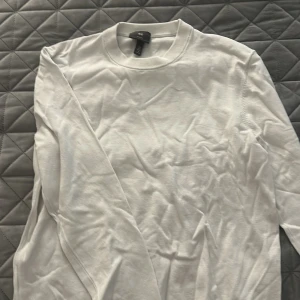 Vit långärmad tröja från H&M - Vit långärmad tröja från H&M i slim fit-modell. Enkel och clean design med rund halsringning och mjukt bomullsmaterial. Perfekt för dig som gillar en stilren och basic look. Passar till allt och är lätt att matcha med andra plagg.