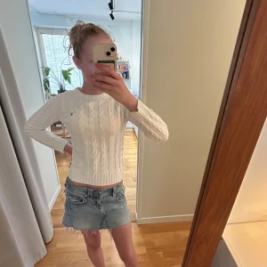 Vit kabelstickad tröja från GANT - Vit kabelstickad tröja från GANT med en diskret broderad logga. Tröjan har rund halsringning, ribbade muddar och lång ärm. Perfekt för lager-på-lager och snygg till jeans och kjol. ❤️jag är 164 för referens, skriv vid funderingar 🥰