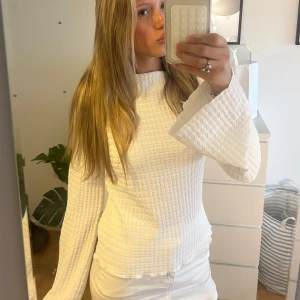 Vit blus med vida ärmar - Supersöt vit blus med vågig struktur och vida, långa ärmar. Inte använd så många gånger och hinner inte riktigt till användning. Perfekt inför hösten men även nu i sommar 💕