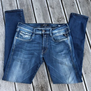 Replay Anbass jeans blå, stl 31 - Säljer ett par Replay Anbass jeans i klassisk blå tvätt med snygga slitningar och kontrastsömmar. Modellen har fem fickor, slim passform och raka ben. Perfekta för dig som gillar en stilren och modern look. Kom gärna med offer och frågor👌