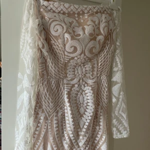 Champagnefärgad paljettklänning med mönster - Superfin långklänning i champagnefärg med vita paljetter i ett detaljerat mönster. Klänningen har långärmade meshärmar och en figurnära passform. Perfekt för dig som vill sticka ut med en unik look och älskar glittriga detaljer.köpte den för 1499 från Dennis maglič. Hade den på mig en gång och ser helt nytt. Priset kan variera 🫶🏻