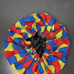 Satinbonnet med Afrikanskt mönster  - Snygg satinbonnet med elastisk kant och coolt grafiskt mönster i rött, gul och blå. Insidan är slät svart satin som skyddar håret. Perfekt för att hålla frisyren på plats under natten.