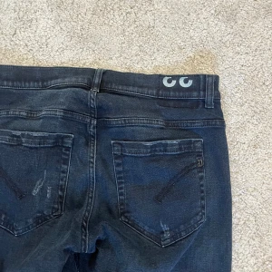 Dondup jeans - Säljer ett par svarta jeans från dondup med snygga slitningar och hål på framsidan. Jeansen är i bra skick, storlek 33. Hör av er vid frågor!