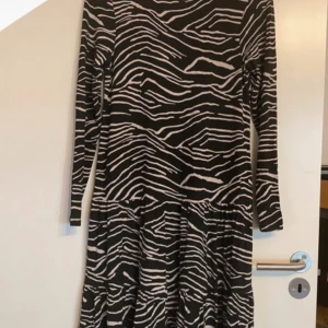Klänning - Säljer en klänning från Mywear i fint skick, storlek S. Färgerna är svart och vitt med ett tiger-mönster. Snygg och unik design.