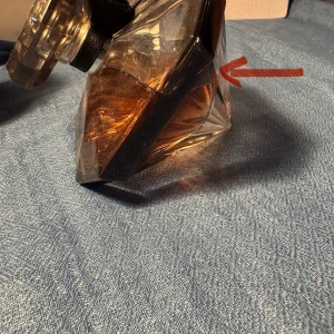 La Nuit Trésor parfym från Lancôme - Säljer en La Nuit Trésor parfym från Lancôme. Flaskan är diamantformad i genomskinligt glas med svart och roséguld ton, dekorerad med ett svart band runt halsen. Parfymen har en varm bärnstensfärgad vätska och en lyxig känsla.