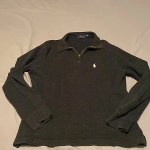 Svart Half Zip tröja från Polo Ralph Lauren - Säljer en svart långärmad tröja från Polo Ralph Lauren i storlek XS. Tröjan har en liten dragkedja vid halsen och klassisk krage. Den är prydd med den ikoniska vita loggan på bröstet. Perfekt för en stilren och enkel look. Det ända dåliga är att dragkedjefliken är lite sönder men det är inget man tänker på och dragkedjan funkar fortfarande som den ska. Tröjan är bara använd ungefär 2 gånger så den är typ som ny. Bara att höra av er vid frågor o så vidare😊