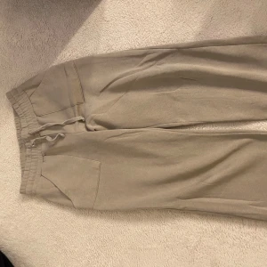 Beige mjukisbyxor med snörning - Säljer ett par grå mjukisbyxor från lager 157. Har aldrig använt då dem va är för stora för mig.
