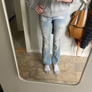 Lowwaist bootcut only jeans ljusblå - Säljer ett par ljusblå bootcut jeans med slitningar och hål på både fram- och baksida. Jeansen har låg midja . Egensydd utsvängda 
