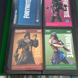 Fortnite samlarkort i pärm - Säljer en samling Fortnite samlarkort från 2020 och 2019 i en svart pärm. Korten visar olika karaktärer från spelet, som Blackheart, Cameo, Elmira, Onesie och fler. Varje kort har färgstark design med karaktärsnamn, nummer och Fortnite-logga. Perfekt för Fortnite-fans och samlare ‼️ Säljer pga spelar inte Fortnite längre. Pris kan diskuteras 🔥