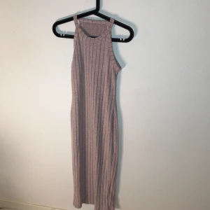 Ljuslila ribbad klänning från SHEIN - Säljer en ljuslila ribbad klänning från SHEIN i storlek S. Klänningen är ärmlös med rund halsringning och har en rak, kroppsnära passform som slutar vid vaden. Perfekt för en stilren och enkel look.