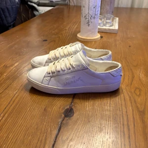 Vita sneakers från Saint Laurent - Tvär sköna unika vita sneakers från ysl. Skick 7-8/10. Skorna är i storlek 39.5 men de sitter som 40-41. Priset är förhandlingsbart vid en snabb affär. MVH vi på von ädi closet🍾